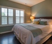 Bedroom with shutters window shades